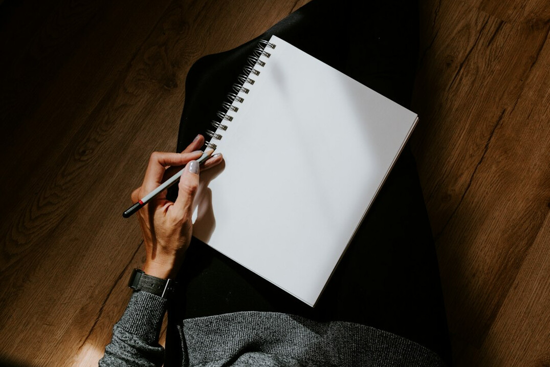 person writing in notebook